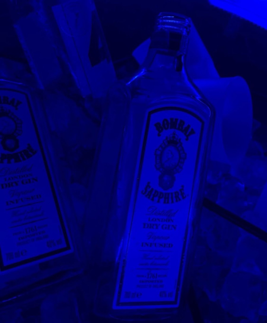 Bottiglie di Bombay Sapphire illuminate di blu al tavolo